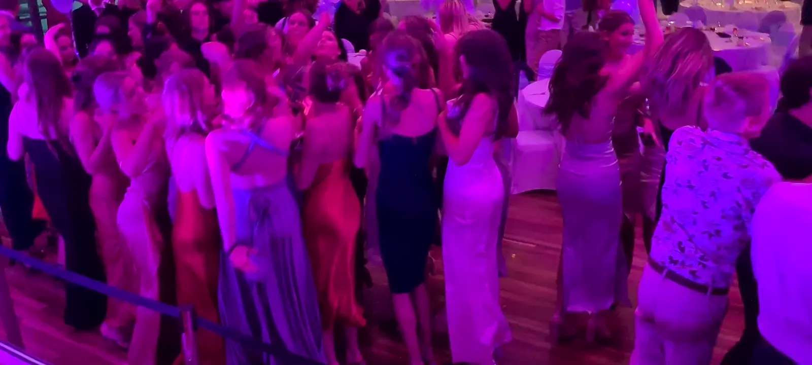Students dancing under purple lighting at a school formal DJ'd by Ultimate DJs