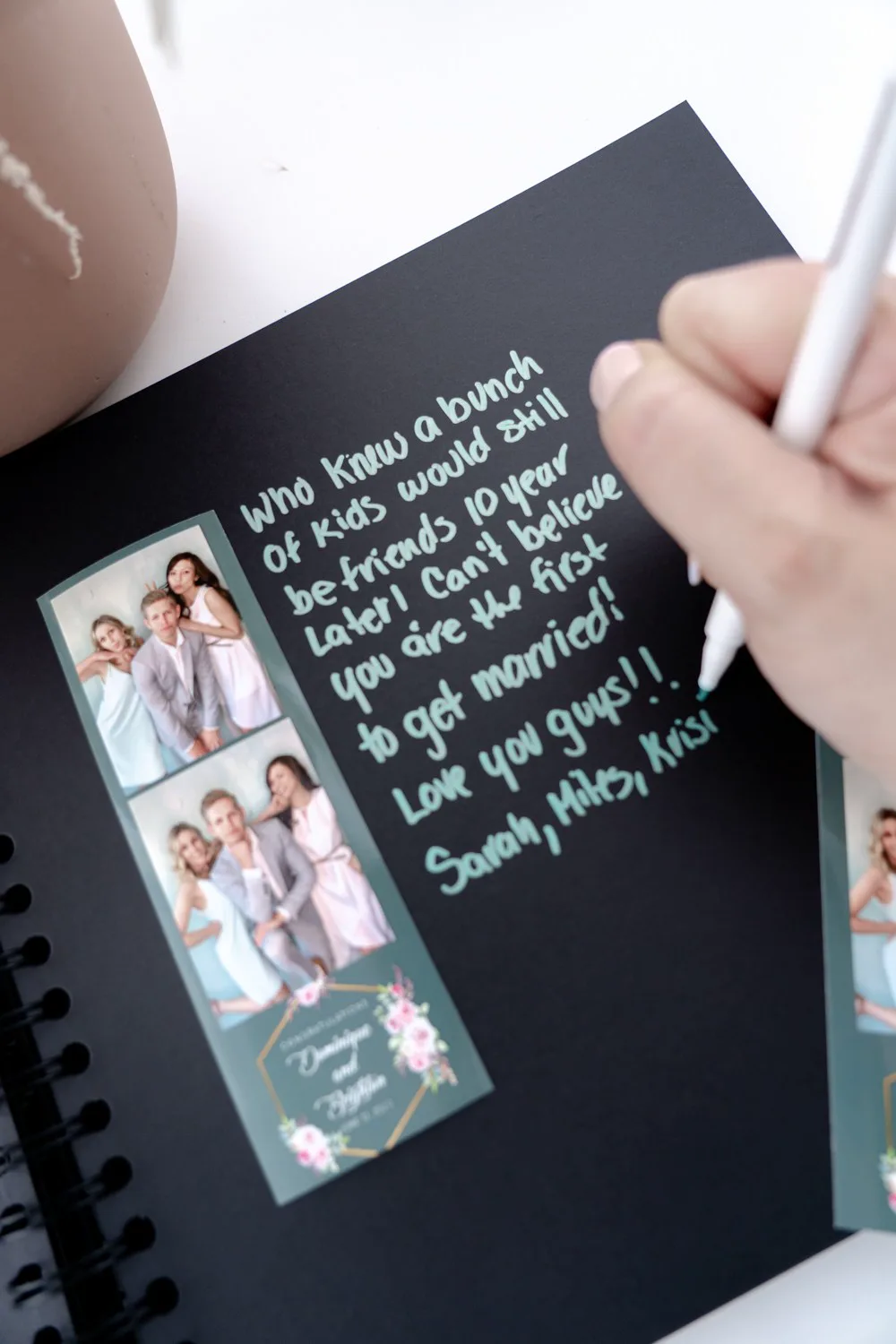 A photo booth print strip in a book, with a handwritten note beside the prints