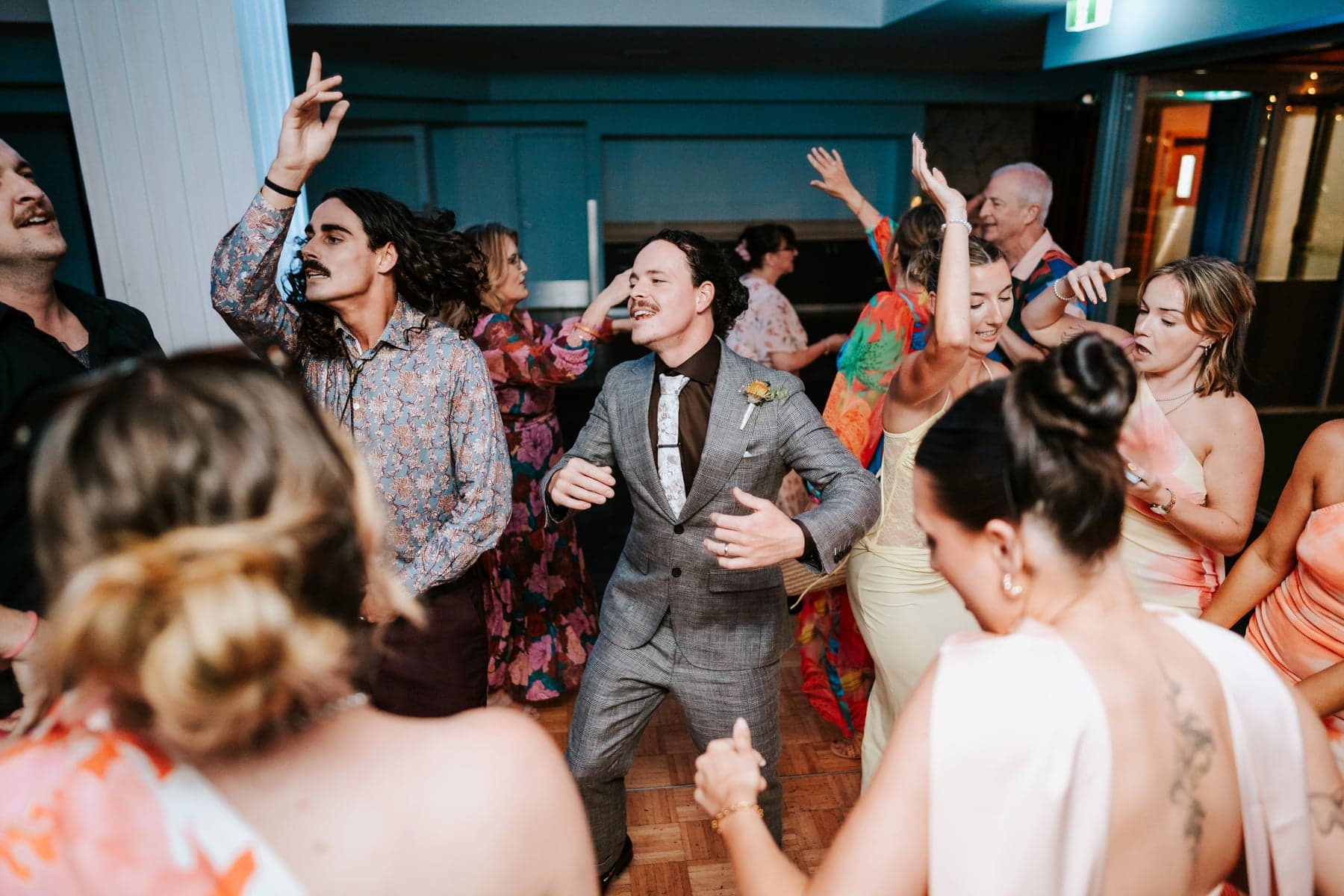 Jesse celebrating in the middle of the dancefloor with wedding guests at The Sebel Kiama